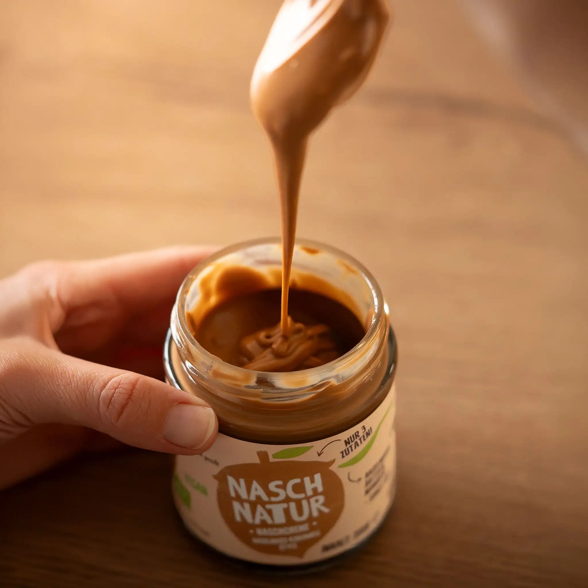 Das Bild zeigt die karamellartige Konsistenz der  Haselnusscreme „NaschMella” von NaschNatur. Ohne Zuckerzusatz.